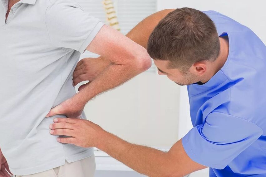 A patient with back pain in a diagnostic examination by a doctor